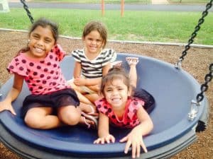 Aboriginal girls playing on a swing