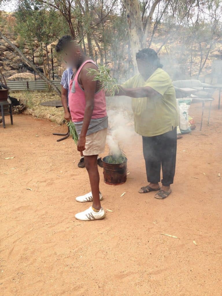One of LeVine's clients at a smoking "welcome to Country". LeVine says the boy was removed from his country and language at a young age and placed "on heaps" of medication. No health worker ever thought of what it would mean for him to be welcomed. He said it was the best day of his life because they were "kind to me" Photo: Supplied