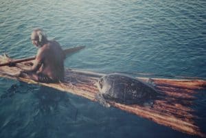 Lee's Dad on a traditional mangrove raft with a freshly caught turtle. 