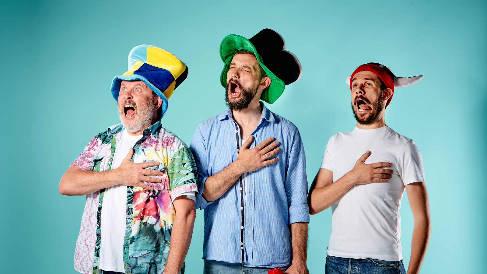 Three white guys wearing silly hats, likely intoxicated, hand on heart, singing the national anthem
