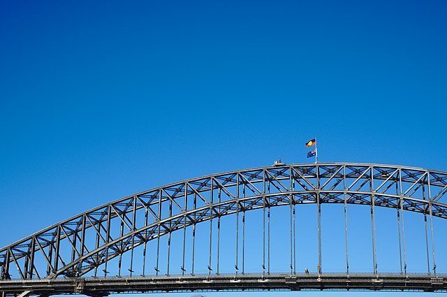 The Sydney Harbour bridge, with the Aboriginal flag on top.
